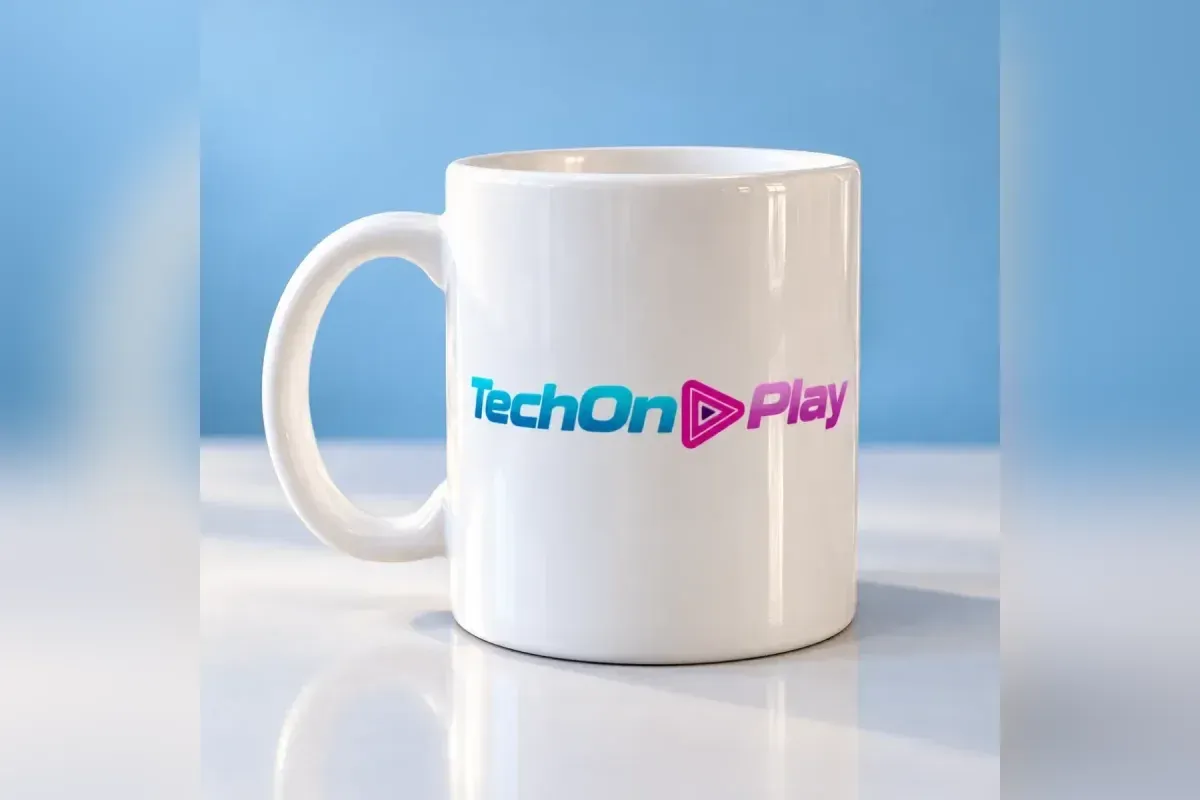 Caneca branca com o logotipo do TechOnPlay de frente, sobre superfície clara e brilhante, com fundo de estúdio azul-claro